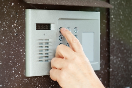 Human finger pushing button of house intercom の写真素材