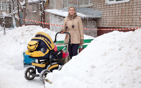 Young woman with pram in winter  