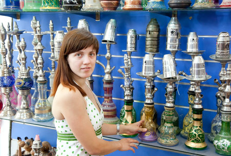 Young woman chooses  sheesha in  shop