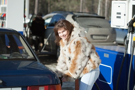 Young  woman poured fuel into the tank cars to pumpsの写真素材