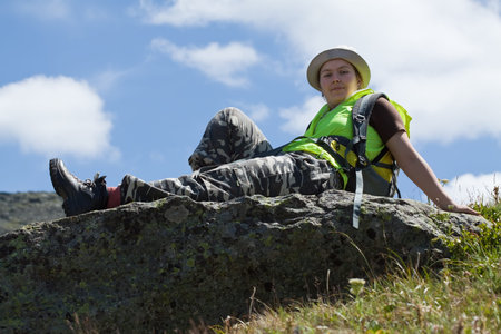 Woman in mountains sitting on the rockの写真素材