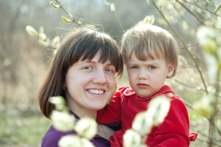 mother with   baby girl in spring pussywillow plantの写真素材
