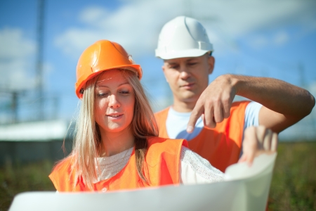 Portrait of two builders standing at electric power plant の写真素材