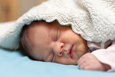 newborn baby sleeps under blanket