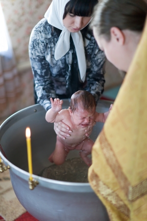 VLADIMIR, RUSSIA  - NOVEMBER 14: Priest at Sretenskaya church performing christening ceremony on November 14, 2012 in Vladimir, Russia. Child - daughter of photographer who gets religious name Elenaのeditorial素材