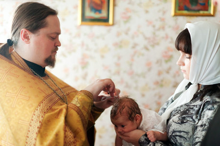 VLADIMIR, RUSSIA  - NOVEMBER 14: Priest at Sretenskaya church performing christening ceremony on...