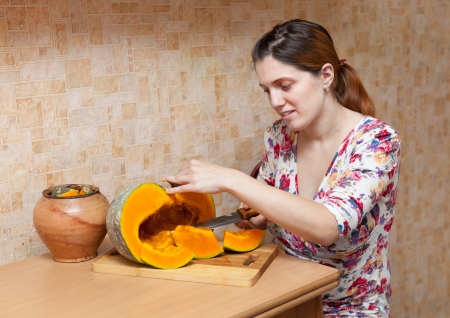 young woman cooking pumpkin at kitchenの写真素材