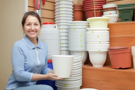 Woman chooses a flower pot in the store for gardenersの写真素材