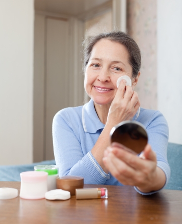 Mature woman removes makeup from the faceの写真素材