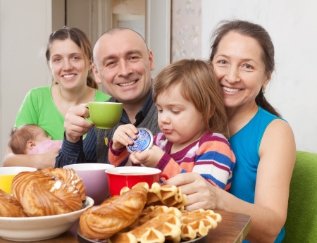 Portrait of  happy three generations family drinks tea with baked at home の写真素材