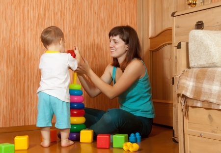 Happy mother and baby plays with pyramidionの写真素材