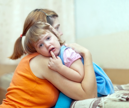 woman soothes crying child. Focus on babyの写真素材