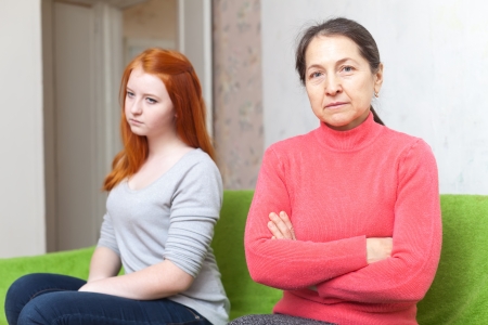 mother and  daughter  after quarrel at home. Focus on mature womanの写真素材