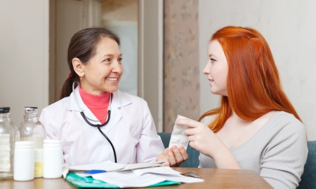 Female teen patient listening the doctor  in clinicの写真素材