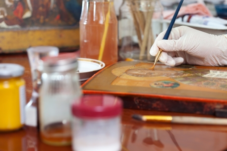 Closeup of   restoration of ancient Christian icon in workshopの写真素材