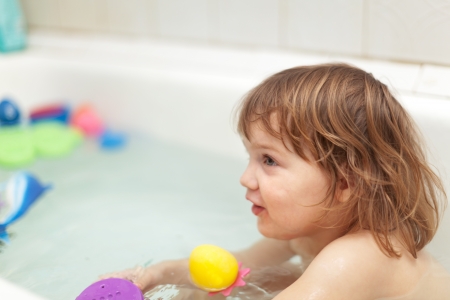  two-year baby girl bathes with toys in bathtubの写真素材