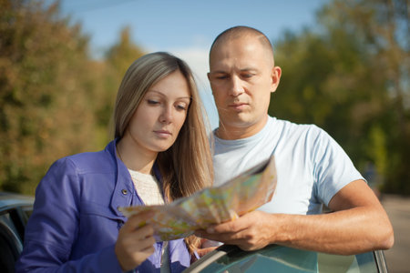  Traveler couple looking at the map on the country road