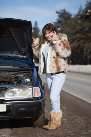 Woman waiting support near  her broken carの写真素材