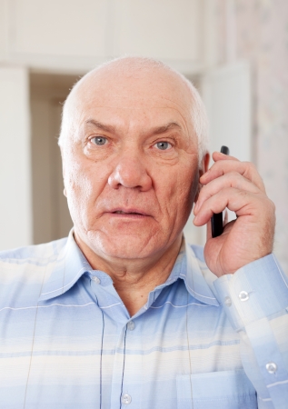 Portrait of quiet handsome senior man speaking by mobileの写真素材