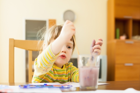 two year child painting on paper with watercolor  in homeの写真素材