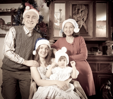 Imitation of antique photo of happy family in Santa hat celebrating Christmas  の写真素材
