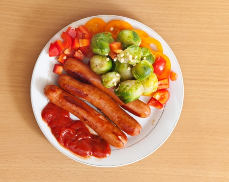 Top view of grilled sausages with broccoli on white plate の写真素材