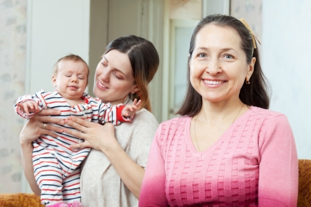 Portrait of happy grandmother with  young mother with baby on backgroundの写真素材