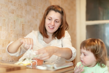 Woman with child cookis in the kitchen togetherの写真素材
