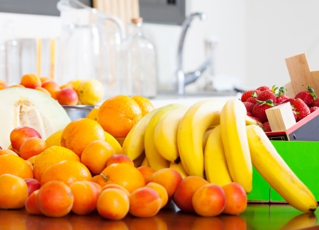 Heap of fresh fruits at table in domestic kitchen  の写真素材
