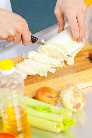 Close up of man cuts lettuce with knifeの写真素材