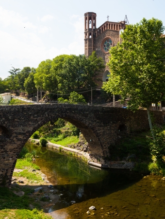  view of ancient church and medieval bridge, built with volcanic stone in Sant Joan les Fonts. Catalonia, Spainの写真素材