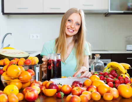 Happy girl making alcoholic cocktail with fruits and ice  の写真素材