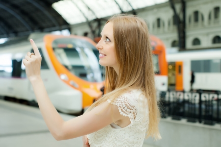 Long-haired woman waiting train at railway stationの写真素材