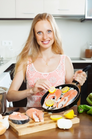  woman cooking salmon  with lemon on griddle at  kitchenの写真素材