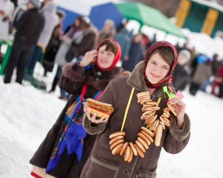 Women  in traditional  clothes with pancake during  Maslenitsa festivalの写真素材