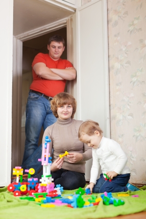 Happy mother and baby plays with toys in home. Focus on woman onlyの写真素材