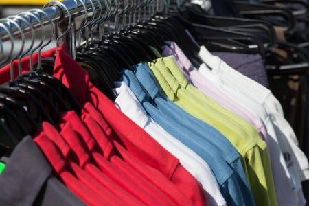 Multicolored shirts on hanger at storeの写真素材