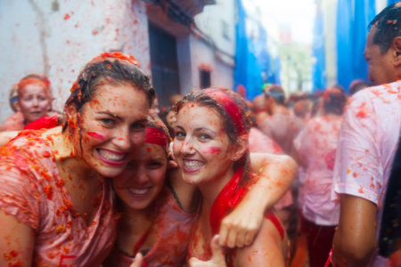 BUNOL, SPAIN - AUGUST 28: People in La Tomatina festival in August 28, 2013 in Bunol, Spain.La Tomatina festival where people are fighting with tomatoes at streetのeditorial素材