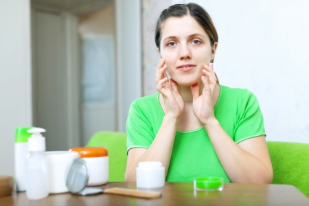 young woman in doing cosmetic mask on her face at home interior
の写真素材