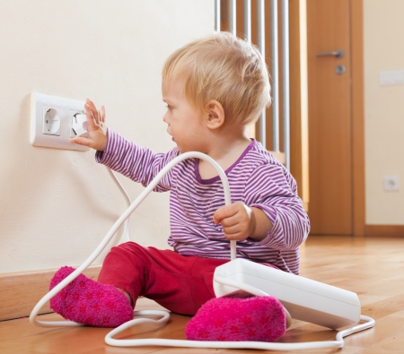 Toddler playing with electricity at homeの写真素材