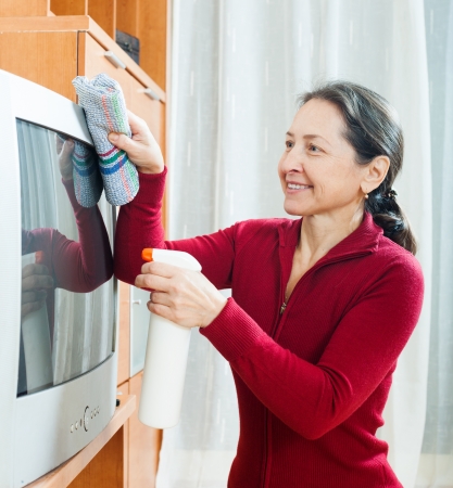 Ordinary mature woman cleaning TV  の写真素材
