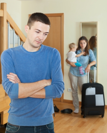 Sadness woman with baby and suitcase leaving from homeの写真素材