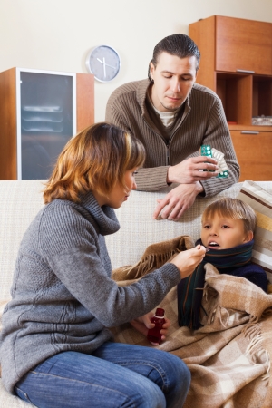 Loving couple caring for sick son in homeの写真素材