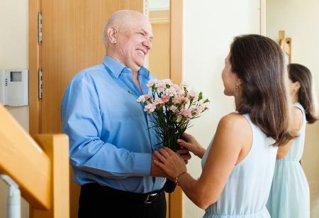 Greeting of loving mature couple at home doorの写真素材