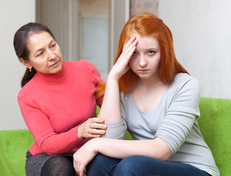 Mature mother asks for forgiveness from teen daughter. Focus on girlの写真素材