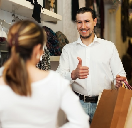Young couple with shopping bags at clothing storeの写真素材