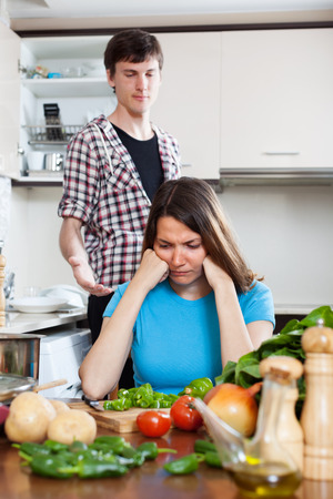 Sad young man and  unhappy woman after quarrel  in kitchen at home の写真素材