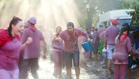 HARO, SPAIN - JUNE 29, 2014: Happy crowd during Haro Wine Festival.People pour wine at each other  from Botas and buckets during festival Batalia de Vinoのeditorial素材