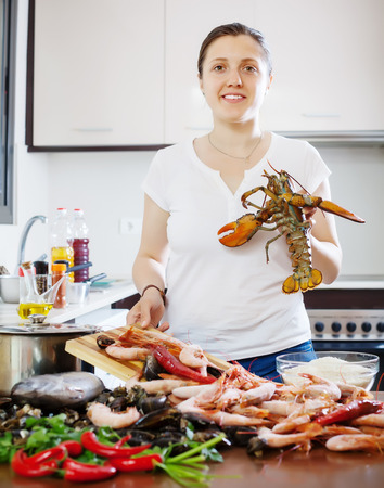 Woman cooks seafood in the kitchen の写真素材