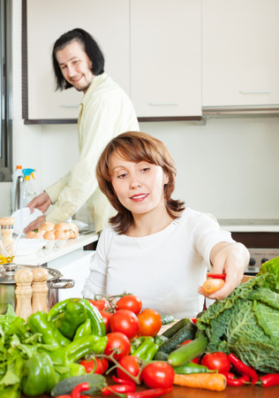  happy couple doing housework together in  kitchenの写真素材